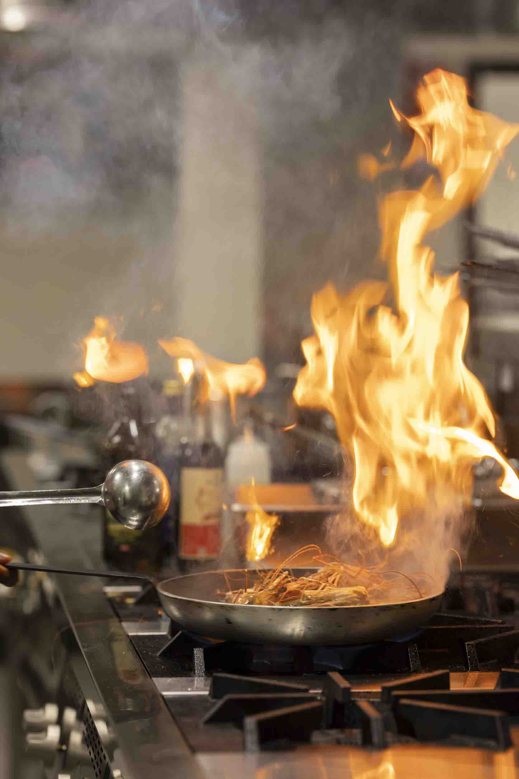 A chef cooking over flames at JW Marriott Mount Kenya Rhino Reserve Safari Camp